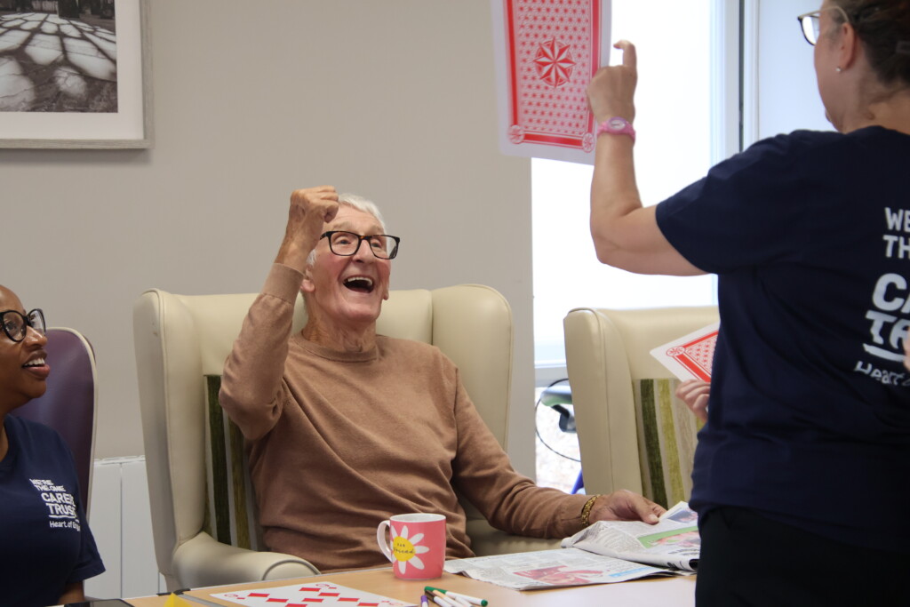 A man at Day Break celebrating winning a card game.